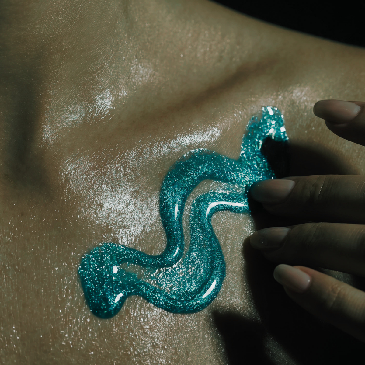 Shimmering aqua dry body oil macro image on decollete